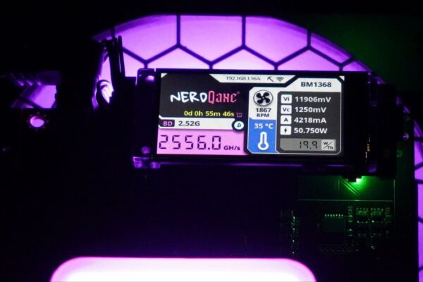 Close-up view of the NerdQaxe+ Hydro mining dashboard showing 2.56 TH/s hashrate, 50.75W power draw, and 19.9 J/TH efficiency on a BM1368 chip with illuminated purple lighting in the background.