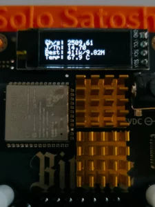 OLED display reading 2509 GH s on Bitaxe Gamma during overclock test with dual gold heatsinks and ESP32 module