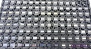 Tray of BM1362AK Bitcoin ASIC chips neatly organized for manufacturing or resale.