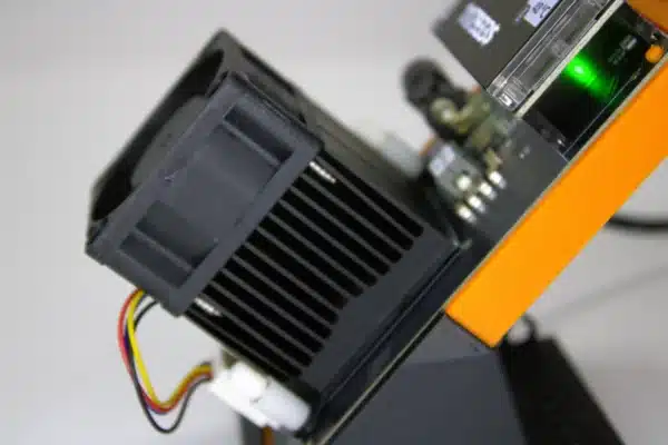 “Close-up side view of NerdAxe Gamma Bitcoin solo miner showing high-density aluminum heatsink, 30 mm fan and status LED”
