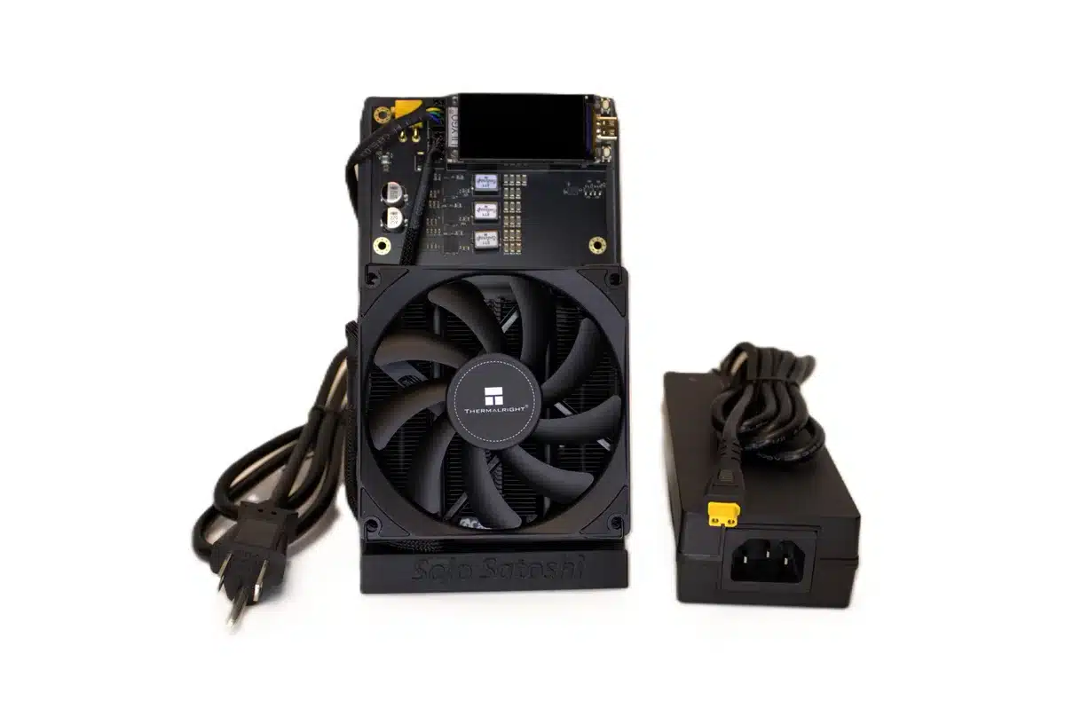 Front view of NerdQaxe++ Revision 6 bitcoin solo miner with 120 mm cooling fan and matching XT30 power brick