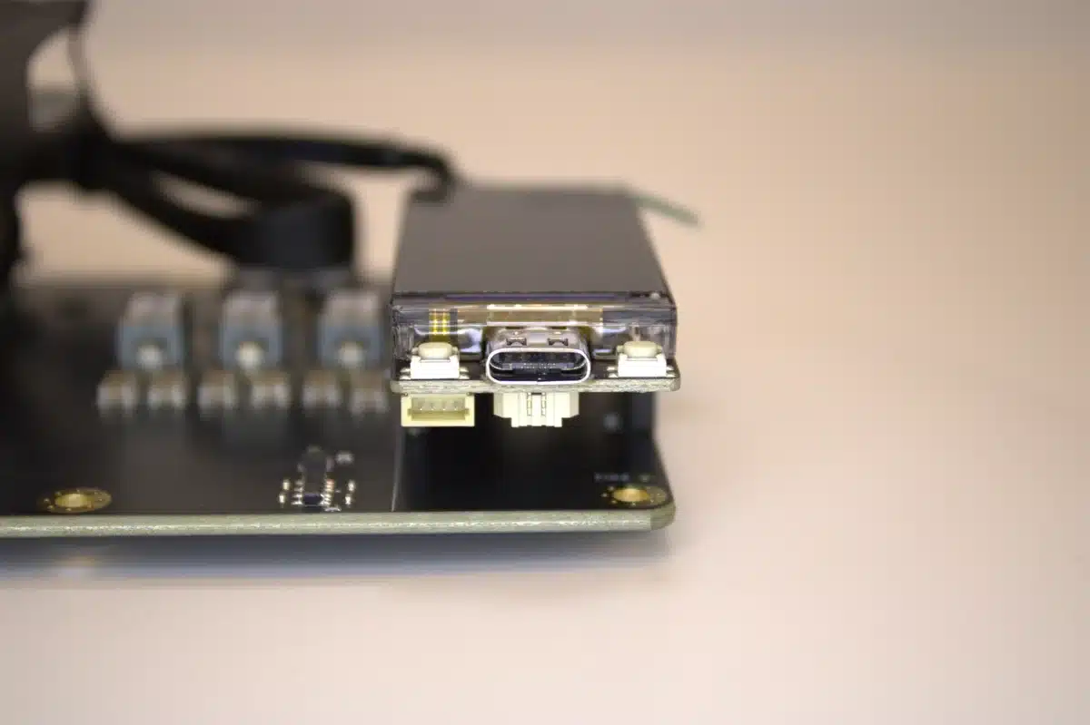 USB-C port and dual buttons on NerdQaxe++ Rev 6 OLED stats module, mounted on black PCB