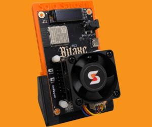 Bitaxe Gamma 602 Bitcoin solo miner on orange Solo Satoshi 3D-printed stand showing Dark Horse heatsink, 40mm cooling fan, OLED display, ESP32-S3 Wi-Fi module, USB-C port, and Assembled in USA badge