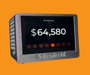 Bitaxe Touch Turbo Edition Bitcoin miner displaying live Bitcoin price of $64,580 on 4.3-inch capacitive touchscreen with eight navigation icons and Solo Satoshi branding on grey enclosed case
