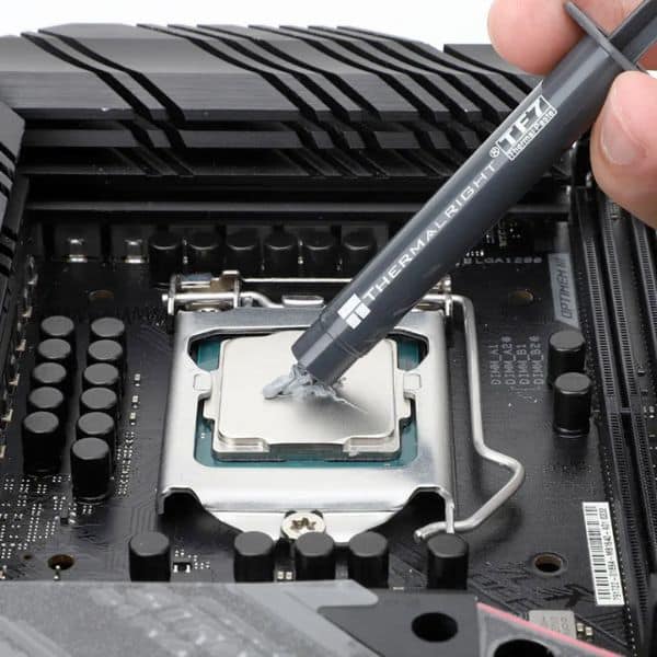 Thermalright TF7 thermal paste applied to Intel LGA1200 desktop CPU socket showing pea-sized drop on processor IHS