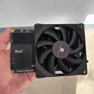 Bitaxe Naja Duo BM1373 Bitcoin solo miner held in one hand showing compact size with Thermalright heatsink and 92mm fan